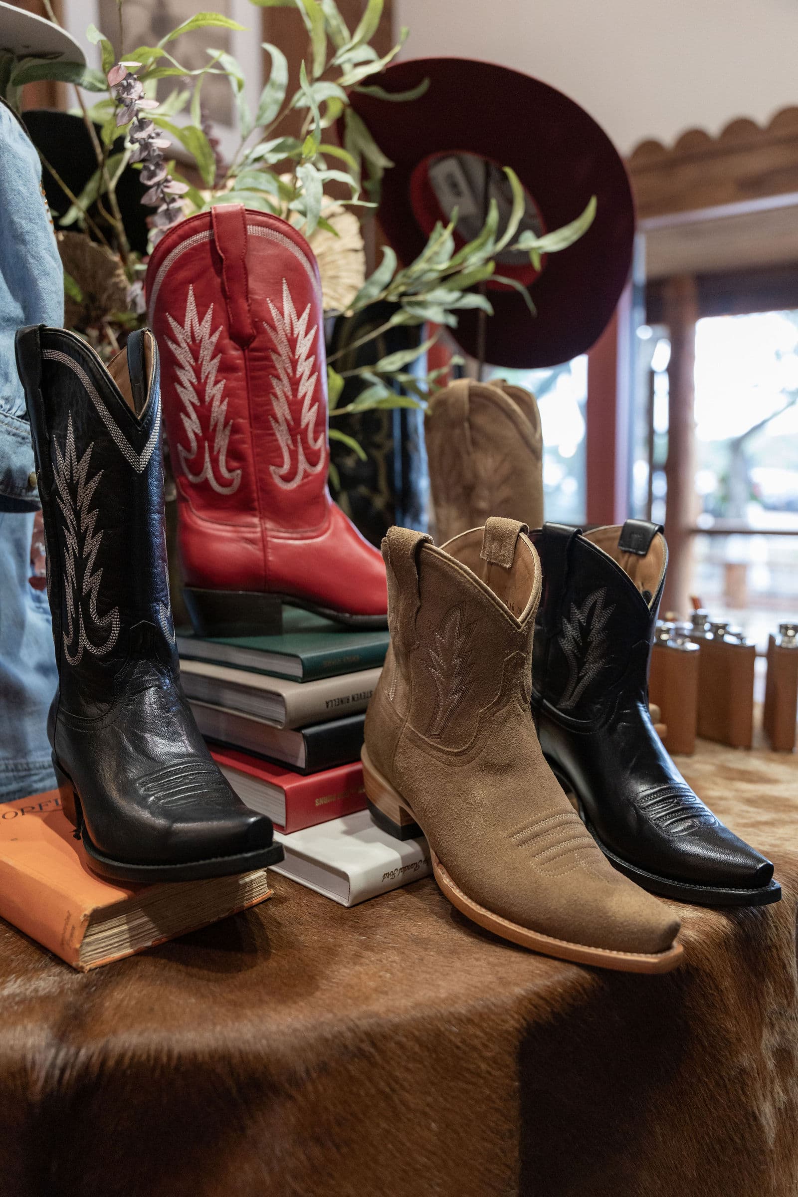Cowboy boots styled on books and cowhide at the Billie Jean Boots launch in Austin