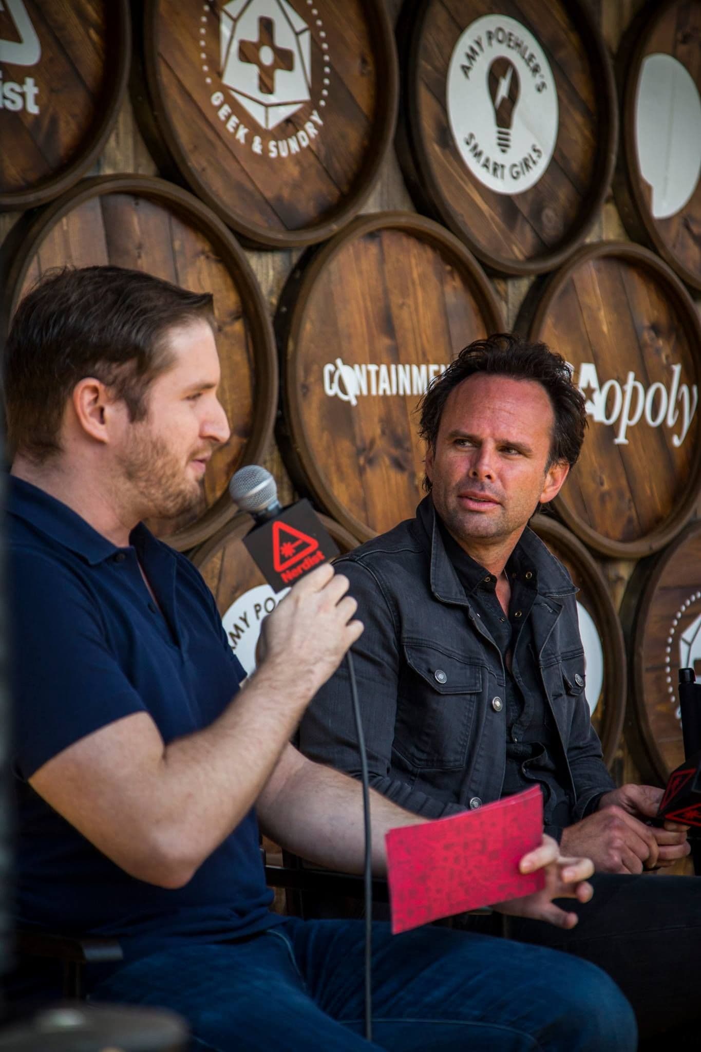 Guests talking at an outdoor activation with event fencing and daylight