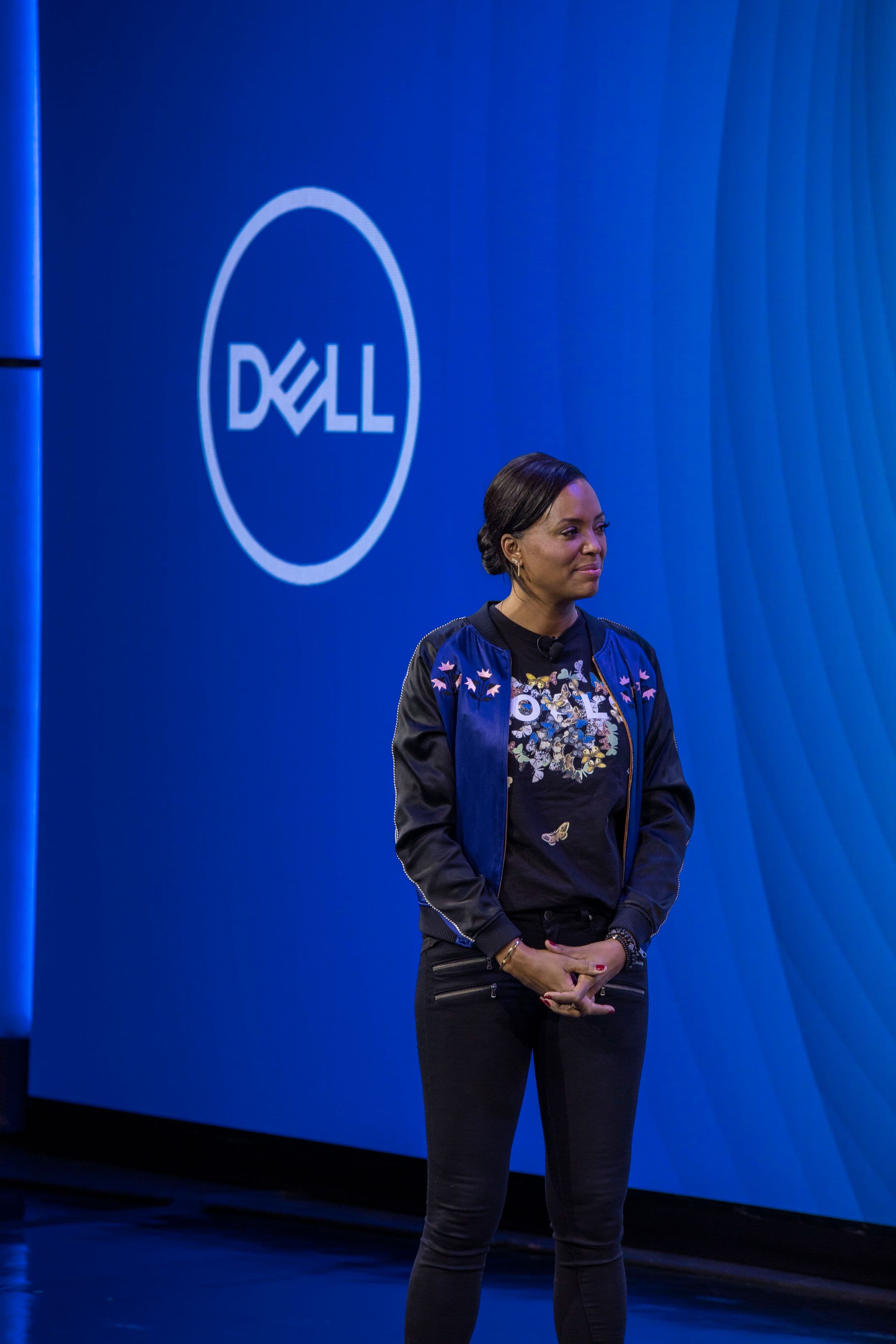 Speaker at a press conference in front of a bright video wall