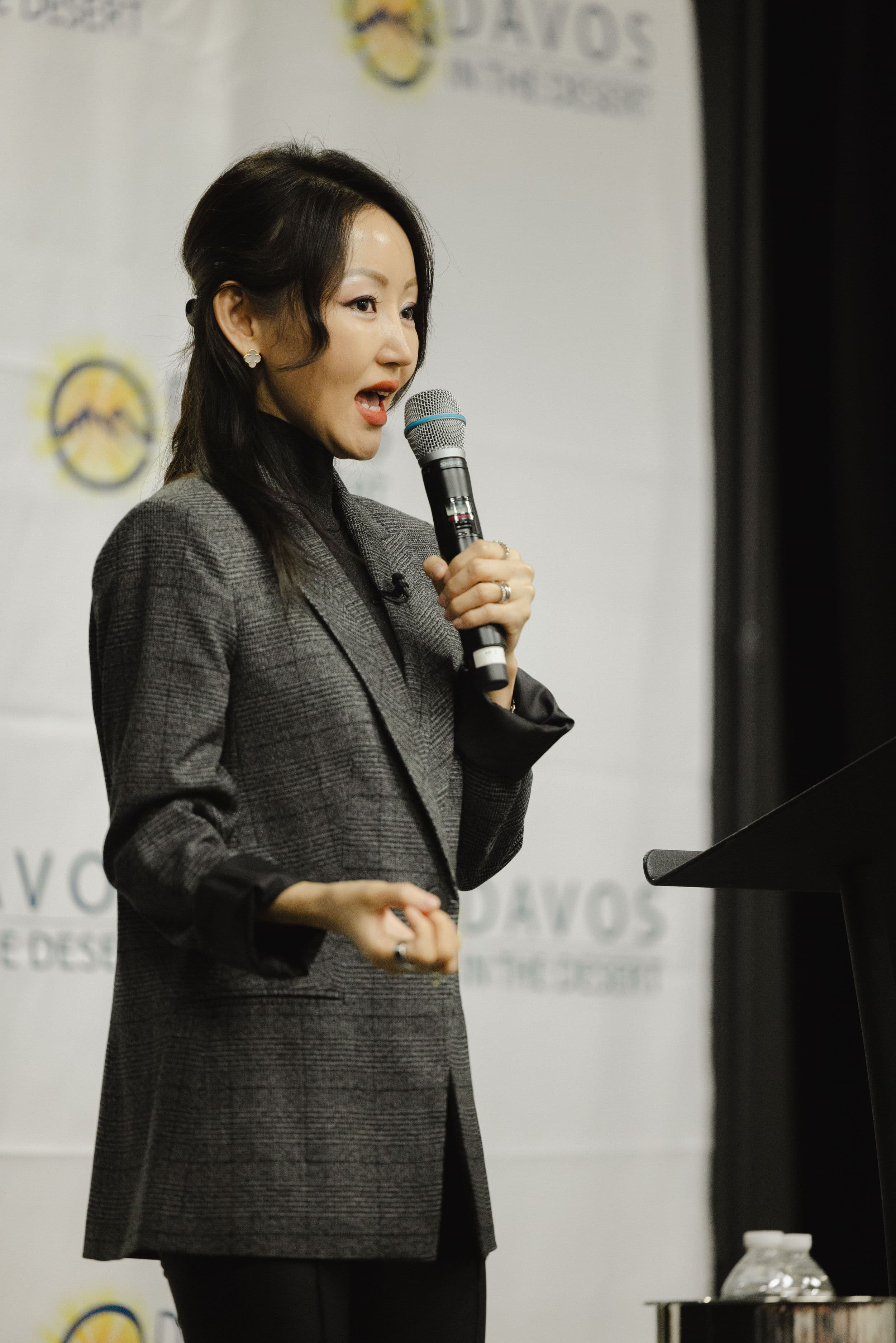 Speaker on a stage at a desert conference, audience in the house