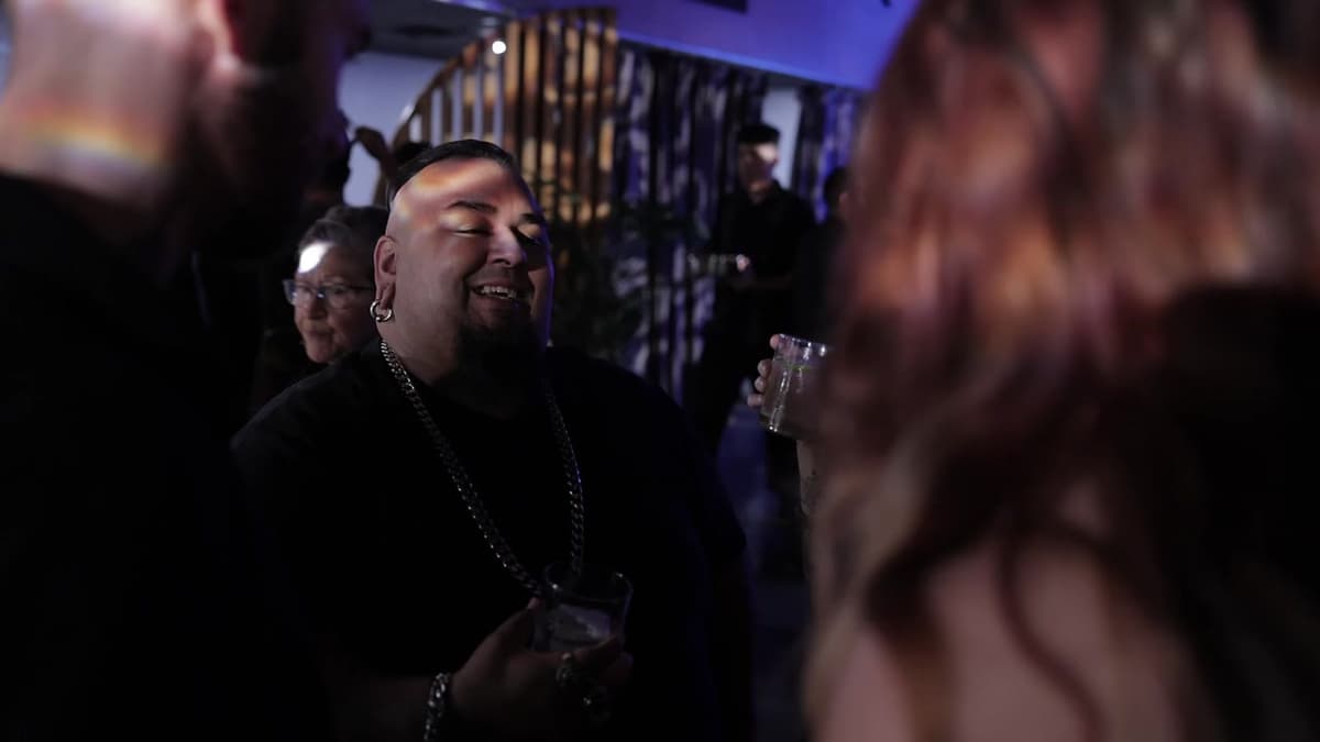 Patron El Cielo Austin film still. A guest laughs with a short glass of ice and citrus.