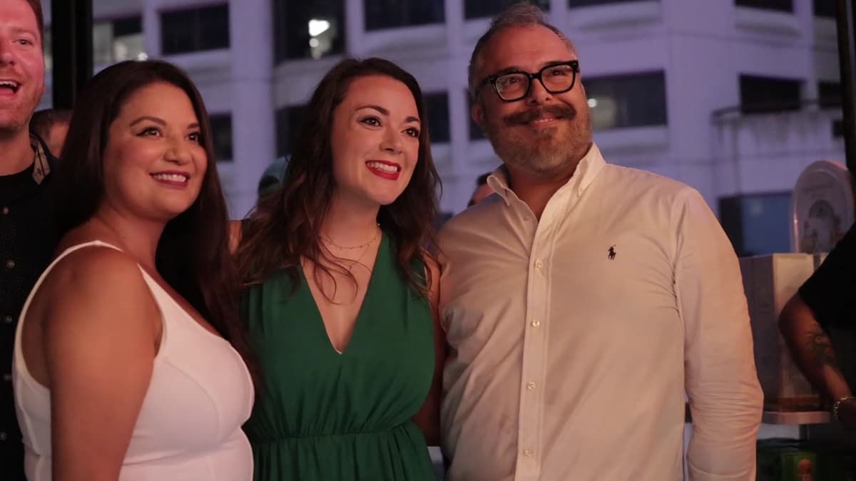 Patron El Cielo Austin film still. Three guests smile with the downtown skyline behind them.
