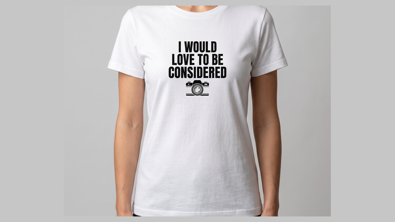 White I Would Love To Be Considered tee, black print on the chest.